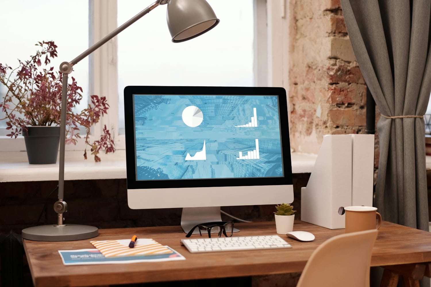 A desktop computer displaying various graphical data on the screen in an indoor workspace.